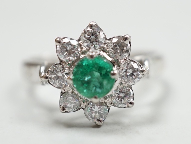 A modern 18k white metal, emerald and diamond set flower head cluster ring, size N, gross weight 4.5 grams.